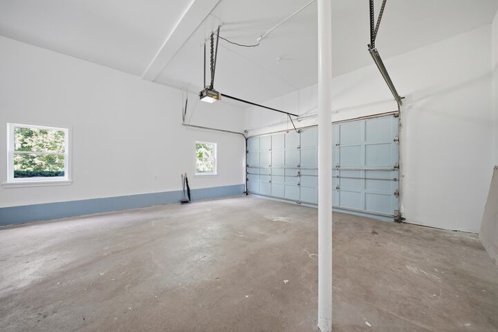 Two-car garage with overhead doors and a concrete floor at 7 Twin Street, Windham, NH